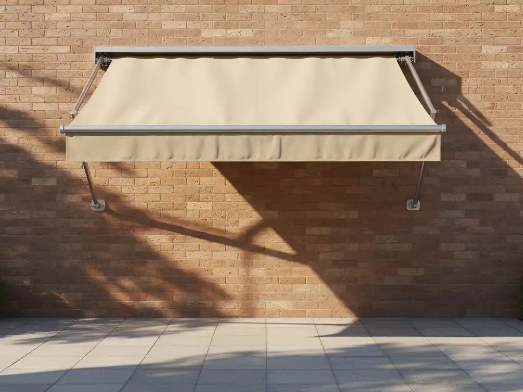 Uitgeschoven knikarmscherm op moderne bakstenen gevel boven zonnig terras, met zichtbare doorhanging en ongelijke spanning in het doek.